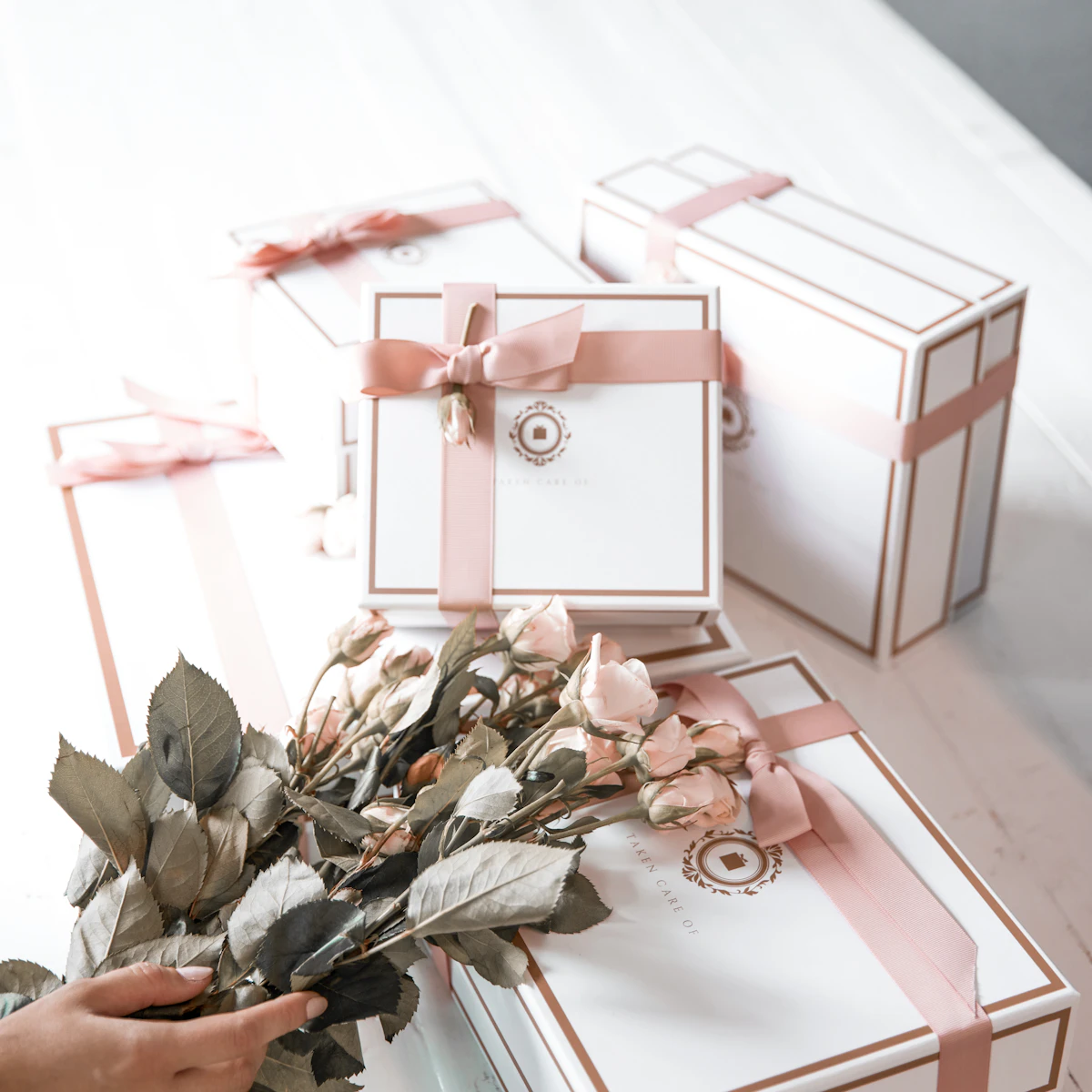 Gift boxes tied with pink ribbon and dried roses